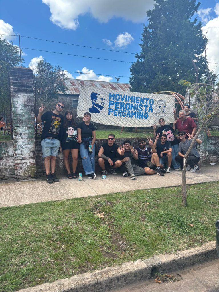Militantes posan con la bandera del espacio en el patio del club.