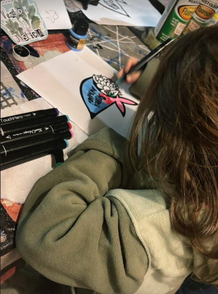 Alguien pinta un pañuelo blanco sobre la mesa de trabajo, antes de la marcha.