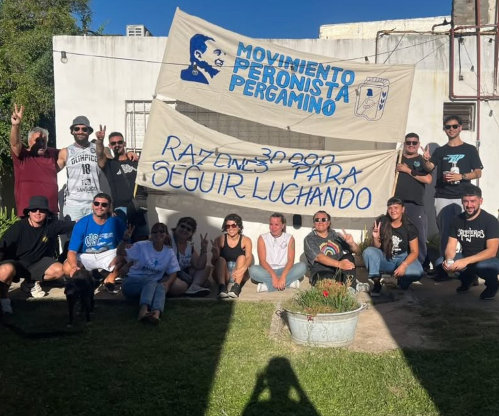 Militantes posan con la bandera del espacio y la de «30.000 razones para seguir luchando».