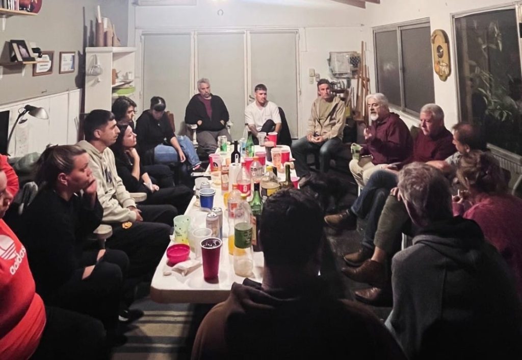 Ronda de conversación alrededor de una mesa larga, durante la charla debate.