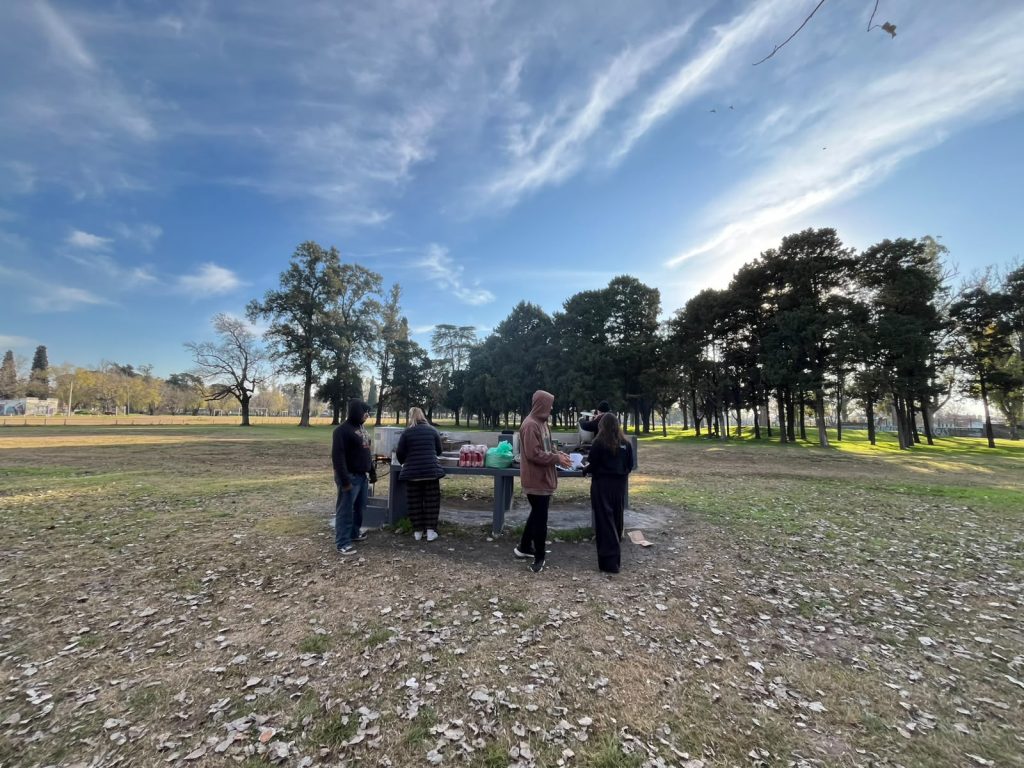 Militantes trabajan alrededor de la mesa del parque, en un día despejado.
