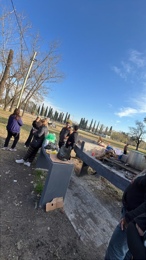 Preparativos de la olla popular en el parque: mesa, fuego y militantes trabajando.