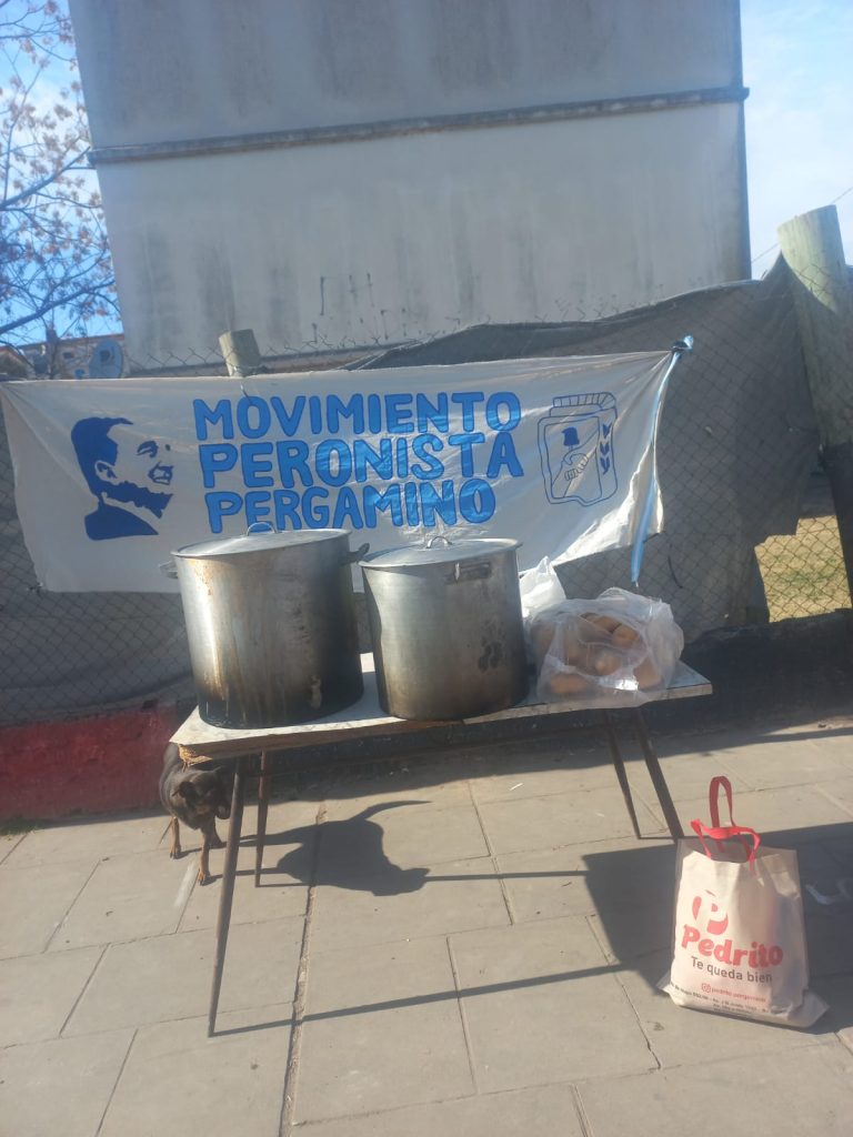 Las ollas y el pan sobre la mesa del puesto, con la bandera del espacio detrás.