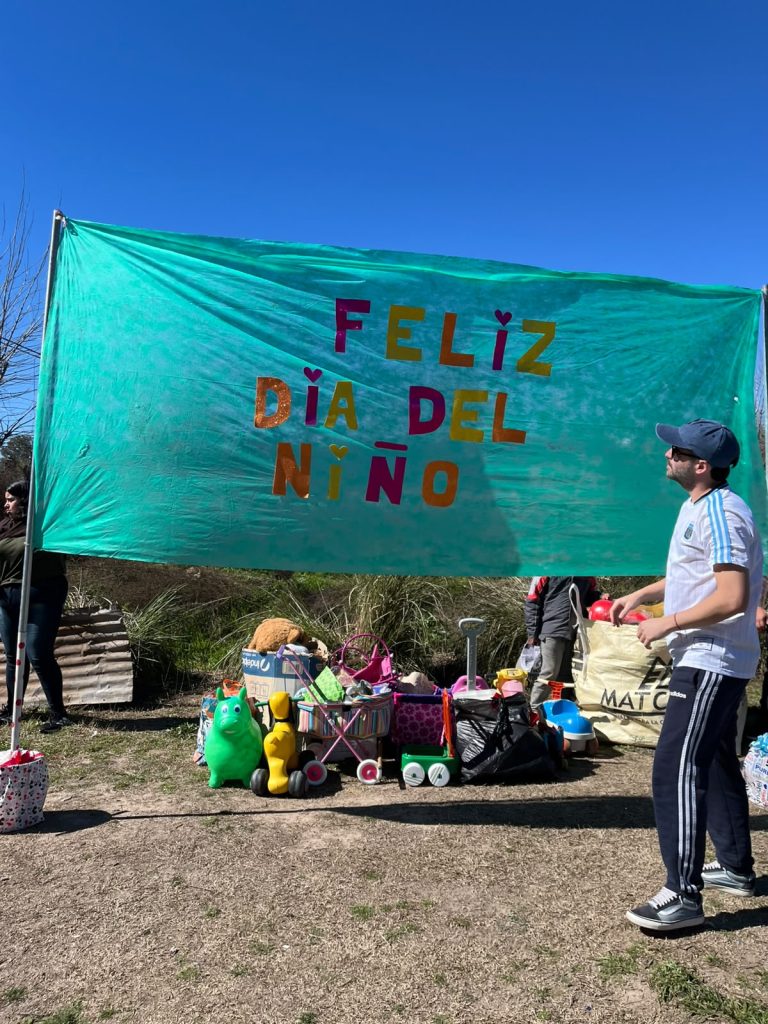 Bandera pintada a mano con la leyenda «Feliz día del niño», sobre la mesa de los regalos.