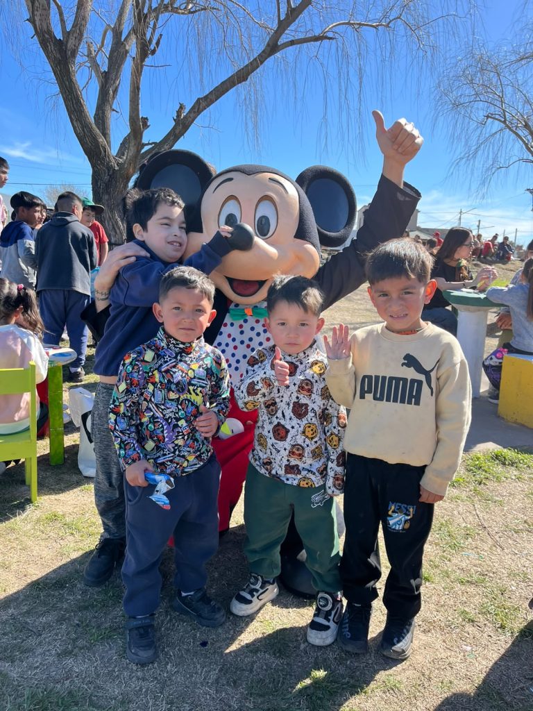 Tres chicos posan con alguien disfrazado de personaje de dibujos animados.