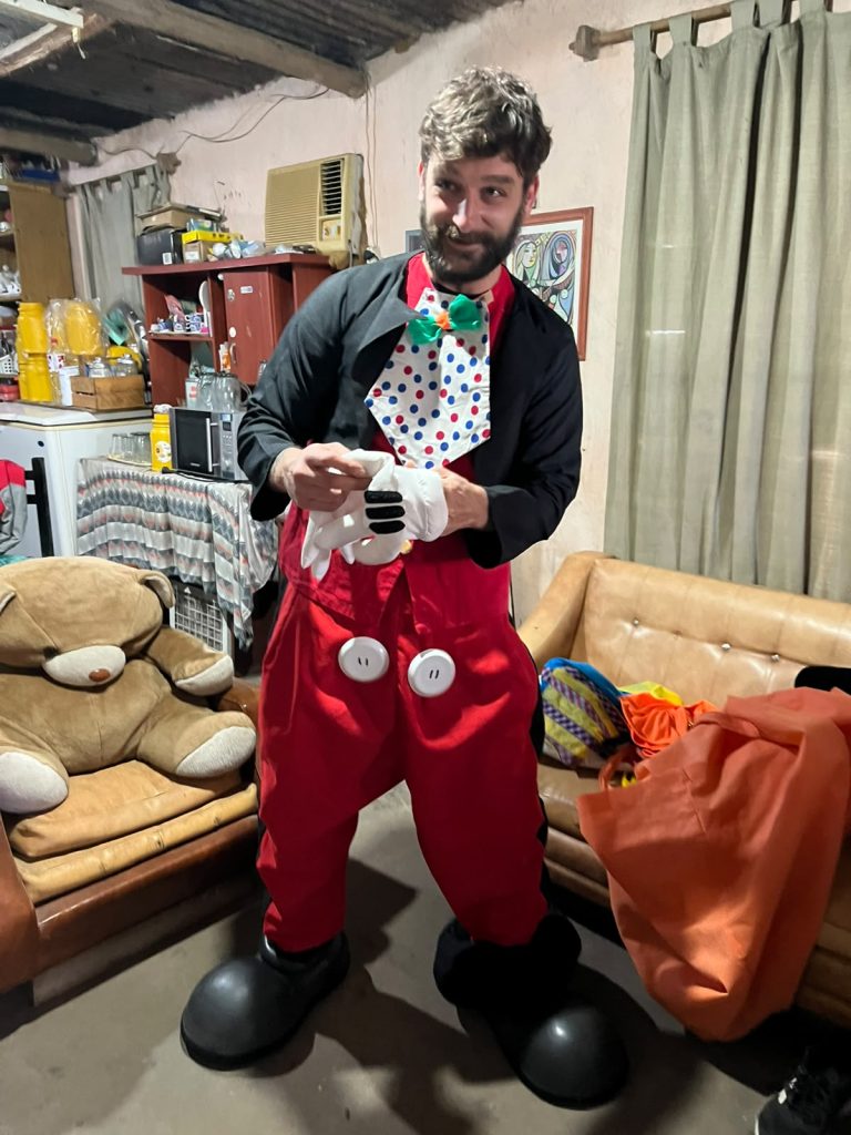 Un animador disfrazado prepara la función para los chicos, adentro del salón.