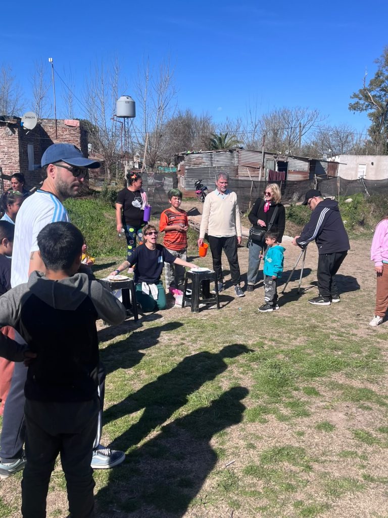 Familias del barrio se acercan a la jornada por el camino de tierra.