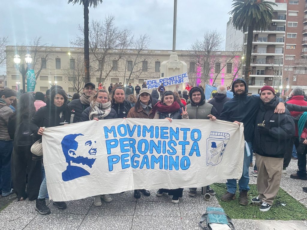 Militantes sostienen la bandera del Movimiento Peronista Pergamino frente al palacio municipal.