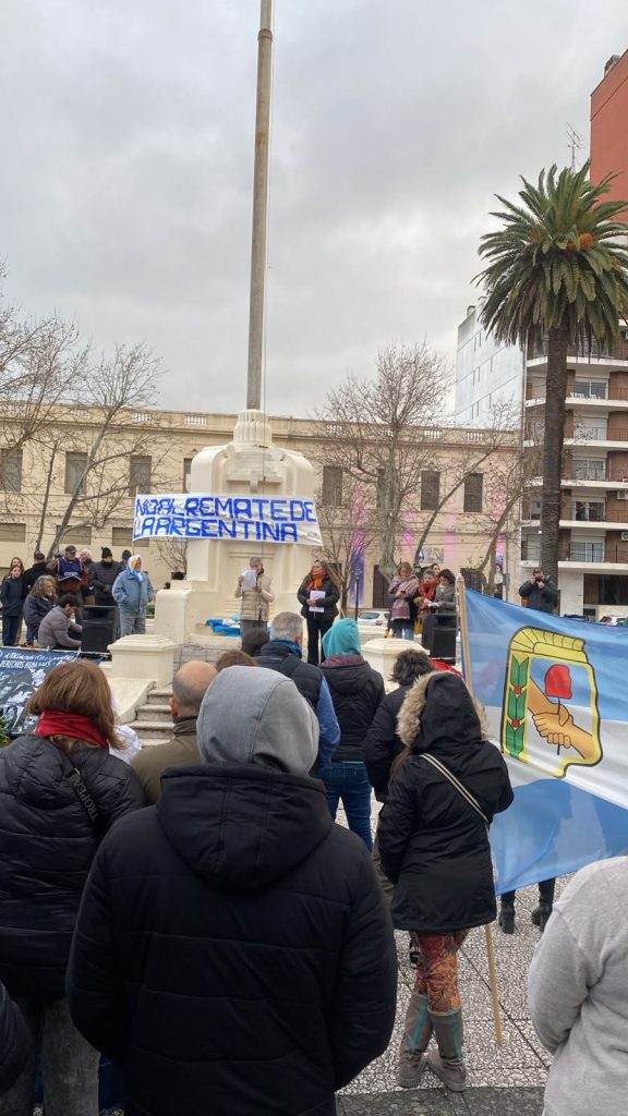 Vecinos con banderas argentinas frente al monumento, durante la concentración.