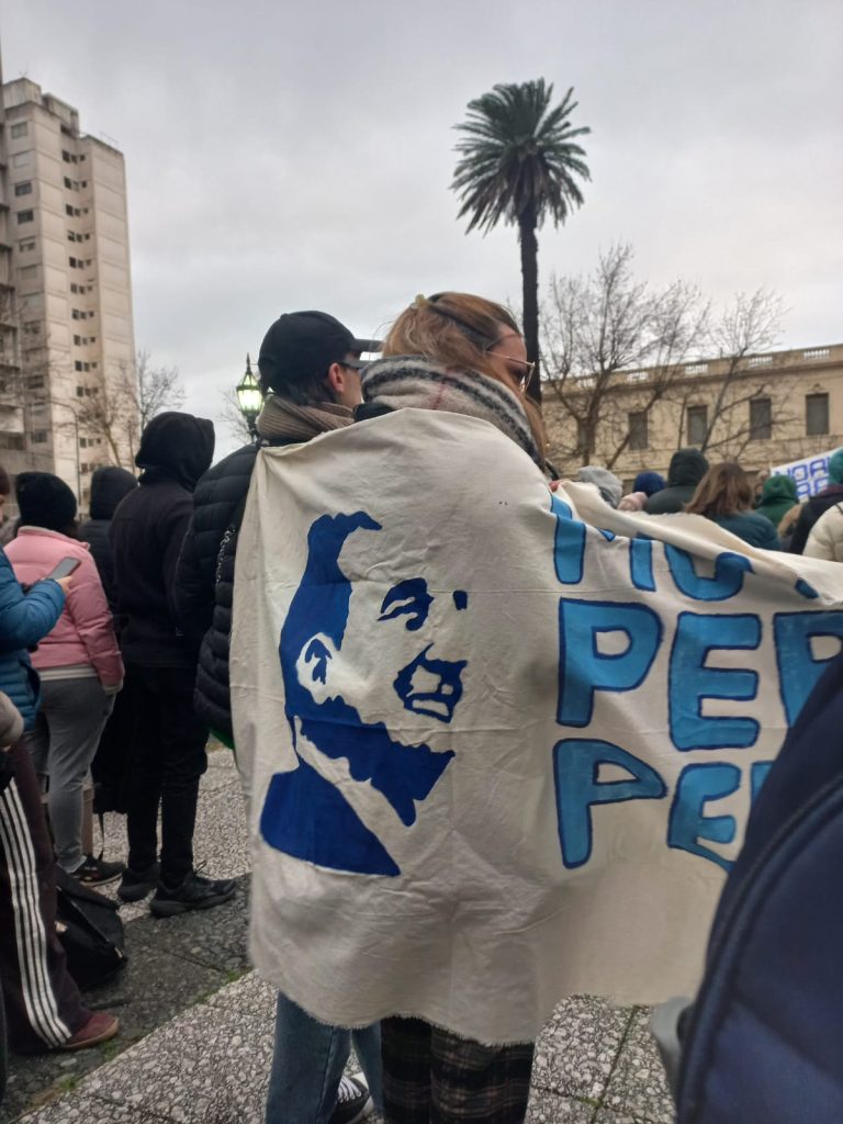 Una militante lleva sobre los hombros la bandera del Movimiento Peronista Pergamino.